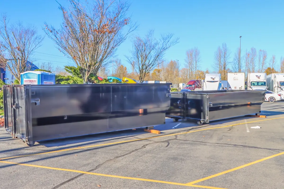 Professional dumpster rental service with roll-off container on residential driveway in Highlands